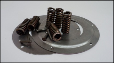 Peças metálicas compostas por molas, parafusos e chapas circulares cinzentas sobre fundo branco