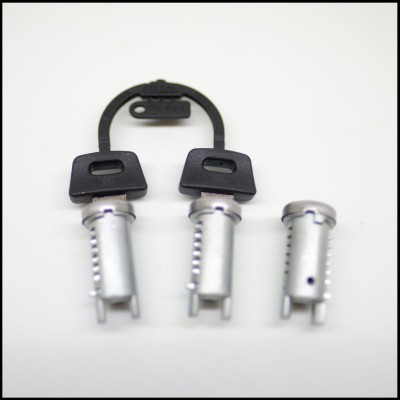 Três pinos metálicos com alças pretas e faixa de plástico preta com texto