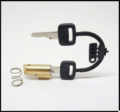 Chave metálica com cabo preto e detalhe numérico 2350 junto a molas metálicas