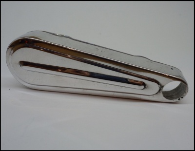 Peça metálica cromada com formato alongado e recorte circular