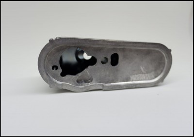 Peça metálica cinzenta com recortes sobre fundo branco