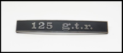 Emblema metálico preto com texto prateado 125 g.t.r.