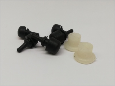 Cinco pequenos rolamentos de plástico, três pretos e dois transparentes, sobre fundo branco