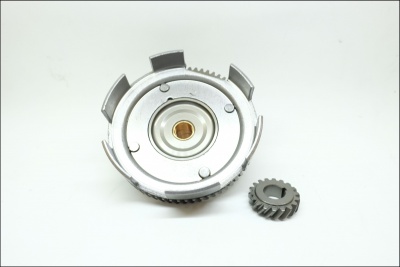 Peças metálicas prateadas, roda dentada maior e engrenagem menor sobre superfície branca