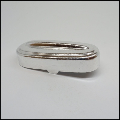 Peça metálica prateada de formato oval longo