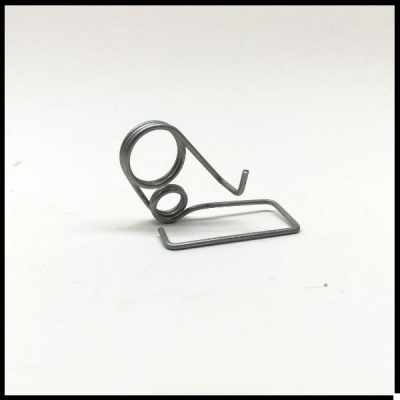 Peça metálica de arame cinzento com espirais e base retangular em fundo branco