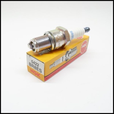 Vela de ignição NGK BR8ES sobre caixa amarela e vermelha