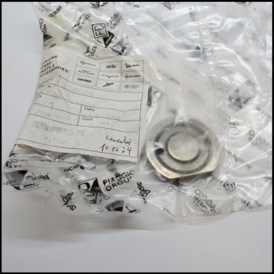 Peça metálica redonda embalada em plástico transparente com etiqueta branca impressa