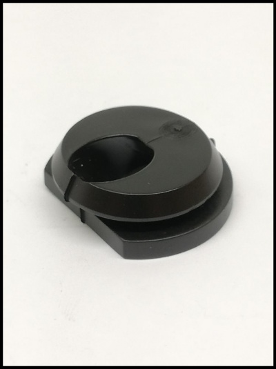 Peça plástica preta redonda com recorte sobre fundo branco