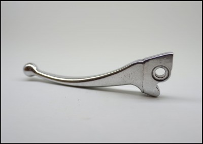 Manete metálico prateado sobre superfície branca