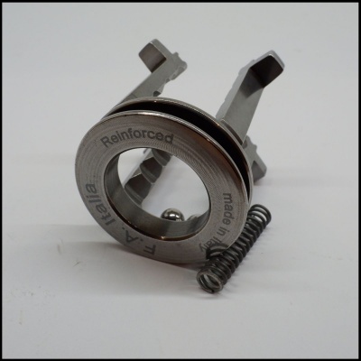 Componentes metálicos incluindo anel reforçado com texto e mola sobre fundo branco