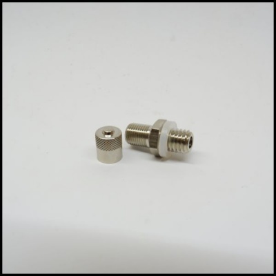 Pequenos componentes metálicos prateados sobre superfície branca