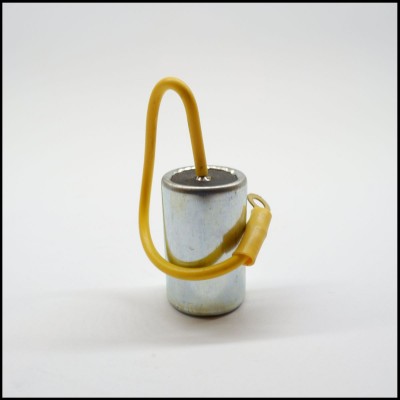 Condensador cilíndrico metálico prateado com fio amarelo ligado