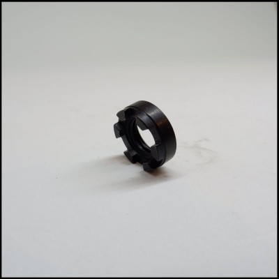 Anel preto de plástico com quatro saliências em superfície branca