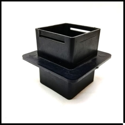 Peça plástica preta quadrada com flange e ranhuras, fundo branco