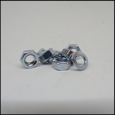Porcas hexagonais metálicas prateadas sobre superfície branca