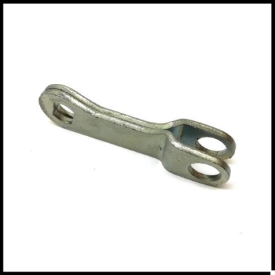 Peça metálica prateada com furos quadrado e duplo circular