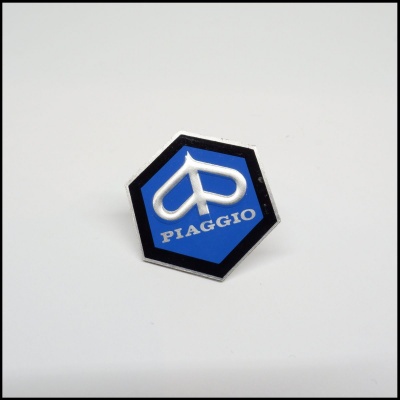 Emblema hexagonal azul e preto com texto PIAGGIO