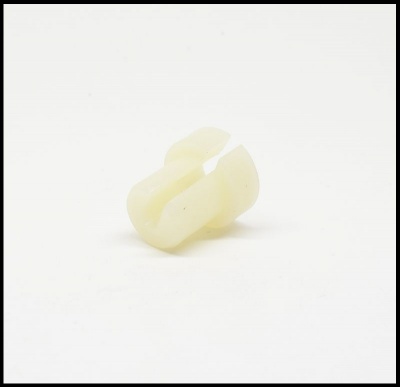 Peça pequena de plástico creme com formato curvado e fenda central