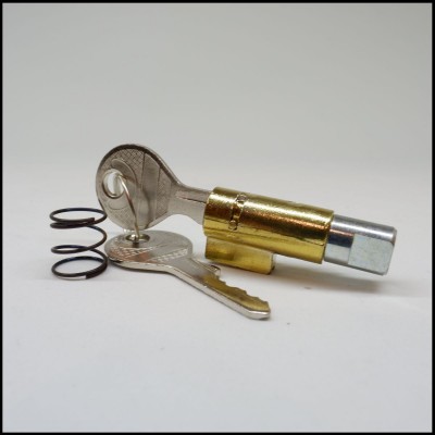 Chaves metálicas, mola preta e peça cilíndrica dourada e prateada com gravação 'GLOB'