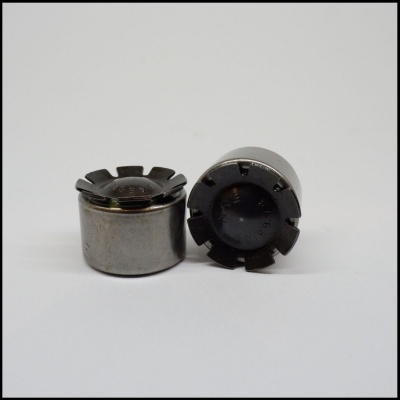 Dois componentes metálicos cilíndricos com topo preto entalhado sobre fundo branco