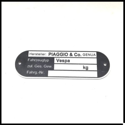 Placa metálica preta oval com texto em branco, marca Piaggio, modelo Vespa