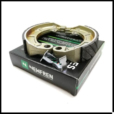 Sapatas de travão NEWFREN metálicas douradas com pastilhas cinzas em caixa preta com logótipo verde.