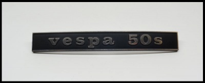 Emblema metálico preto com relevo cinzento vespa 50s