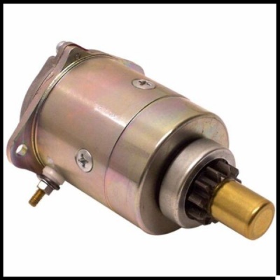 Peça mecânica metálica cilíndrica em tons dourados e prateados com engrenagem e parafusos.