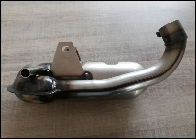 Escape de moto em metal prateado e preto sobre superfície de madeira clara