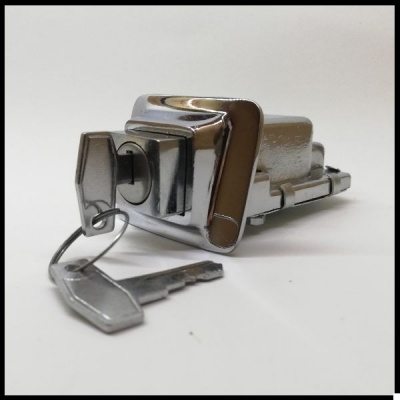 Fecho metálico prateado com chave numa superfície branca