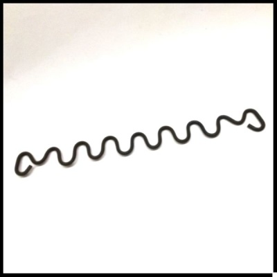 Objeto metálico preto ondulado sobre fundo branco