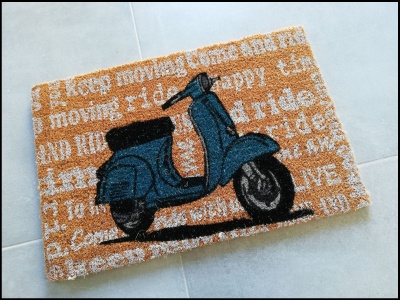 tapete de entrada com desenho de scooter azul e texto sobre fundo castanho