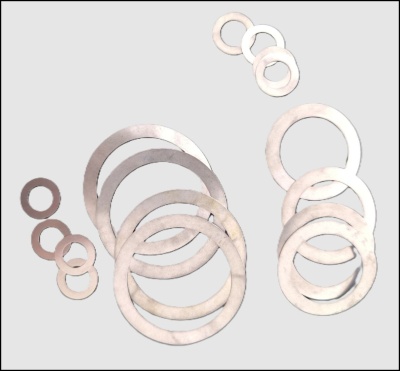 Anilhas metálicas redondas prateadas de vários tamanhos sobre fundo cinza