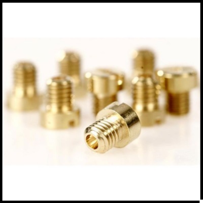 Injetores metálicos dourados com roscas sobre superfície branca