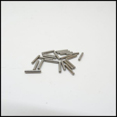 Pequenos pinos metálicos cilíndricos prateados sobre fundo branco