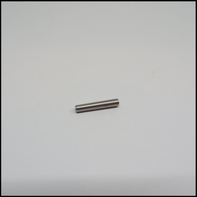 Barra cilíndrica metálica prateada sobre superfície branca