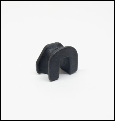 Peça pequena preta em forma de U sobre fundo branco