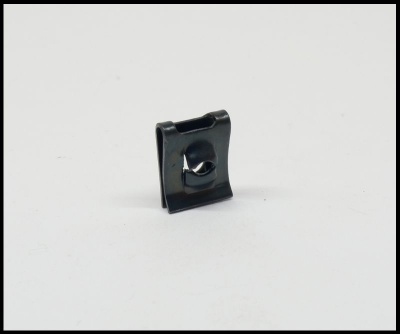 Peça metálica preta pequena sobre fundo branco