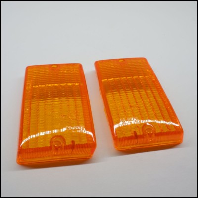 Dois indicadores laterais de automóvel laranja sobre fundo branco