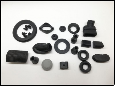 Peças pequenas em borracha ou plástico de várias formas e cores pretas e cinzentas sobre fundo branco