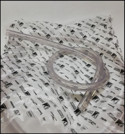 Tubo transparente flexível sobre saco branco com logotipos e texto