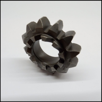 Engrenagem metálica cinza escuro com dentes largos sobre superfície branca