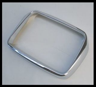 Moldura metálica retangular prateada sobre superfície branca