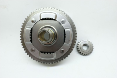 Duas engrenagens metálicas, uma maior e outra menor, sobre fundo branco