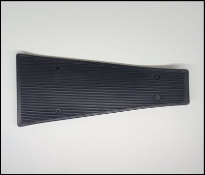 Placa de pedal preta de borracha com estrias e orifícios sobre fundo branco