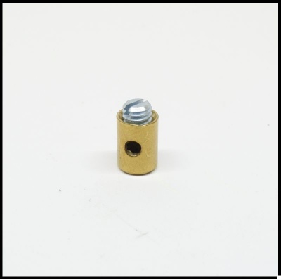 Pequena peça cilíndrica dourada com parafuso prateado e furo lateral