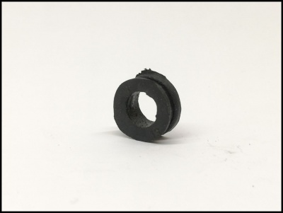 Peça circular preta de borracha com orifício central em superfície branca