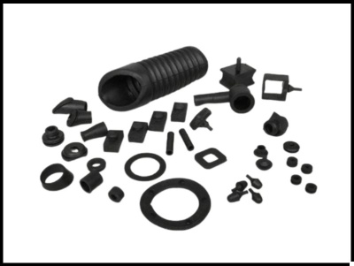 Pequenas peças de borracha preta variadas sobre fundo branco