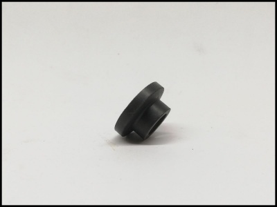 Peça plástica preta cilíndrica com topo plano sobre fundo branco